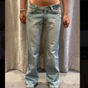  ljusblå bootcut jeans - Ljusblå  jeans med bootcut passform och låg midja. Klassisk femficksmodell med snygga kontrastsömmar och broderade bakfickor. Jeansen har en avslappnad vibe och är tillverkade i mjukt denimtyg. Perfekta för dig som gillar retrostil och vill ha ett par riktigt sköna jeans. Midjemått: 36,5cm tvärsöver, innerben: 81cm