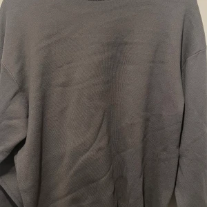 Grå stickad tröja från Zara - Enkel och stilren grå stickad tröja från Zara i storlek M. Tröjan har rund halsringning med ribbad kant och långa ärmar. Perfekt för lager-på-lager och passar till allt. Snygg basic som funkar året runt.