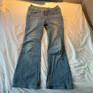 Blå bootcut jeans med mönster - Snygga Brandt Melville jeans med bootcut passform och diskret randigt mönster. Klassisk femficksmodell med normal midja och dragkedja. Perfekta för dig som gillar en retroinspirerad look med lite extra vidd nertill. Obs kan tidigast skicka 8e augusti! Och de är skräddarsydda så att de passar någon som är 166-170 cm🩷
