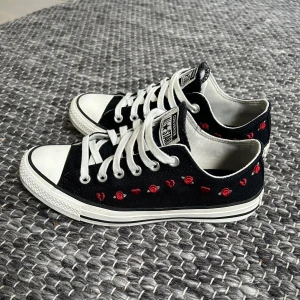 Converse - Säljer ett par Svarta Converse All star med broderade rosor och hjärtan. Dom är 8,5/10 i skick och inte använda mycket. Storlek 39,5 men 25cm så dom passar ca 40,5. Nypris ca 700kr