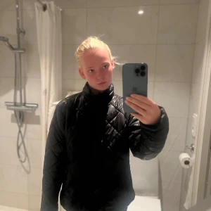 Svart quiltad pufferjacka - Säljer en svart pufferjacka med quiltat mönster och hög krage. Jackan har knappar framtill och är långärmad. Perfekt för kyliga dagar och riktigt snygg till streetwear-stilen. Inköpt för 349 kr 