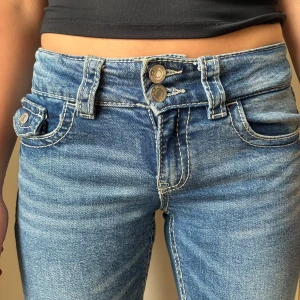 Low Waist jeans - Snygga blå jeans med bootcut passform och dubbla knappar i midjan. Säljer på grund av att de är för korta för mig. Pris kan diskuteras!!❤️