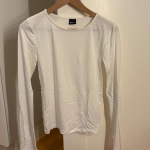 Vit långärmad topp från Gina tricot med slitt nertill - Super fin vit topp från Gina tricot med vit slitt nertill.🤍