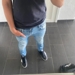 Replay Jeans - Säljer ett par Replay Hyperflex jeans i ljusblå tvätt. De har klassisk femficksdesign, smal passform och stretchigt material som gör dem riktigt bekväma. Perfekta om du gillar jeans som sitter snyggt och är lätta att röra sig i.