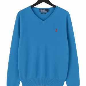 Blå v-ringad tröja från Polo Ralph Lauren - Snygg blå v-ringad tröja från Polo Ralph Lauren med röd broderad logga på bröstet. Tröjan är i bomull och har långa ärmar samt ribbade muddar vid ärmslut och nederkant. Perfekt för dig som gillar klassisk och stilren look. (Första bilden är Ai därför märket ser konstigt ut)