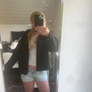 Svart kappa med knappar - Säljer en svart, stilren kappa med klassisk krage och stora knappar framtill. Jackan har en rak passform och är lite kortare i modellen, vilket ger en snygg och modern look. Perfekt att slänga på sig över en hoodie eller t-shirt. Från lager 157 xs 💞