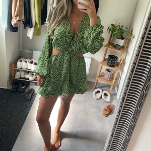 Grön kortklänning med zebra-mönster - Säljer en grön kortklänning med vitt zebramönster. Obs sytt upp klänningen själv!!