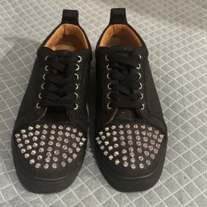 Louis Flat Veau Velours/Spikes - Christian Louboutin skor med glittrande ovandel i mocka och silverfärgade nitar på tån. Skorna har klassisk röd sula, svarta skosnören och läderfoder. Skriv för fler frågor eller bilder i chatten tack!