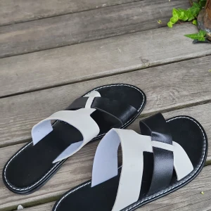 Svartvita sandaler 💗 - Snygga sandaler i svart och vitt med korsade remmar över foten. Platt sula med vit söm runt kanten ger en clean look. Perfekta för varma dagar och enkel att matcha med sommarens outfits.