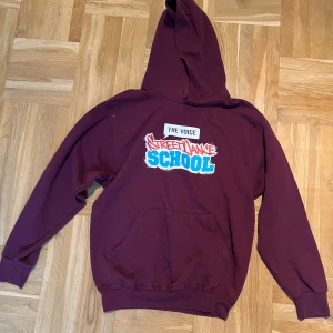 Bordeaux hoodie Street Dance School - Säljer en bordeaux hoodie från Herless med coolt Street Dance School-tryck på ryggen. Tröjan har huva, magficka och långa ärmar. Perfekt för dig som gillar streetstyle och dans. Skön och avslappnad passform.