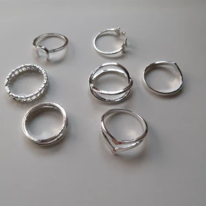 7-pack silverfärgade ringar - 7 st stilrena ringar i silverfärg: måne, lövblad & dubbellager design. Materialet är alloy. (636)