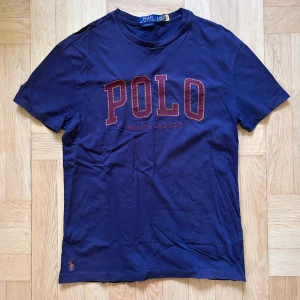 Ralph Lauren Marinblå t-shirt - Marinblå T-shirt från Ralph Lauren. Storlek S men passar mer som en M. Använt med bra skick. Nypris 1200kr. Hör av er ifall ni har några frågor!