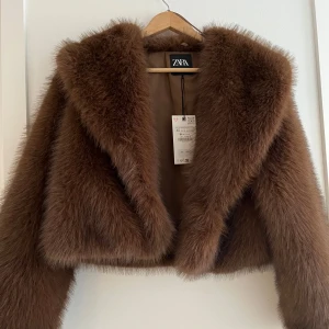 Brun pälsjacka från Zara XS - Säljer en brun pälsjacka från Zara i storlek XS. Jackan är croppad med bred krage och har en riktigt fluffig och lyxig känsla. Helt oanvänd. Skriv för mer bilder