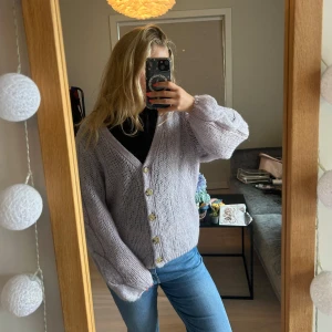 Ljuslila stickad kofta från Lindex - Supermysig ljuslila stickad kofta från Lindex med v-ringning och stora knappar framtill. Koftan har en loose passform och långa ärmar, perfekt att slänga över en t-shirt eller topp. Enkel och stilren design som är lätt att matcha. Använd en gång!