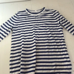 Randig kortklänning i bomull - Säljer en klassisk randig tröja med marinblå och vita ränder. Tröjan har lång ärm och är gjord i mjuk bomull, perfekt för en avslappnad och stilren look.