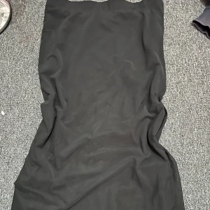 Svart kjol  - En stilren svart kjol från lager 157 i storlek S. Kjolen har en rak och enkel siluett utan synliga detaljer eller mönster, vilket ger en klassisk och tidlös look. Perfekt för dig som gillar minimalistisk stil.