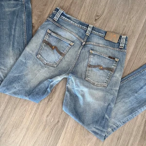 Nudie jeans - Nudie jeans | Modell Grim Tim | Bra skick men har blivit lagade mellan benen | Storlek W33 L32. 