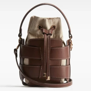 Handväska bucket bag - Fin och eftertraktad handväska från H&M, säljer för kan inte lämna tillbaka. Helt ny, helt oanvänd. Perfekt inför sommaren.