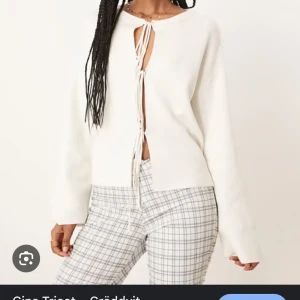 Gräddvit kofta med knyt - Säljer en gräddvit kofta med långa ärmar och trendiga knyt framtill. Koftan har en rak passform och är perfekt att styla över ett linne eller topp. Enkel och stilren design som passar till många outfits.