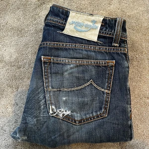 Blå jeans från Jacob Cohën - Skick: 8/10, lappade hål ser ut som design - Storlek: 30 - Längd:96cm Midja:37cm ben:17,5cm - Nypris: 5000 kr+