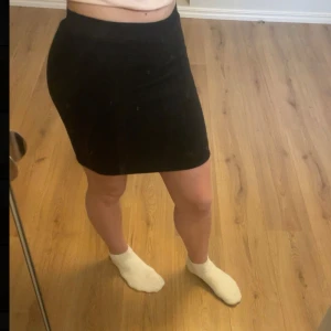 Svart ribbad kjol från Happy Holly - Säljer en svart ribbad kortkjol från Happy Holly. Kjolen har en tight passform och är tillverkad i stretchigt material. Säljer för att den inte kommer till användning, inga defekter💗