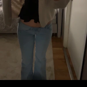 Ljusblå bootcut jeans - Säljer ett par ljusblå jeans med bootcut-modell och låg midja. Jeansen har klassisk femficksdesign och är perfekta för dig som gillar en retroinspirerad look.