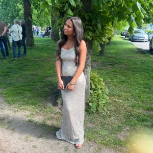 Glittrig champagne bal klänning med öppen rygg - Säljer en glittrig bal klänning i champagne med smala axelband och öppen rygg med snörning. Klänningen har en tight passform och är perfekt för bal eller fest. Materialet är syntet och den har en elegant, skimrande finish. Jag är 163 och har även på mig klackar på bilderna! Använd 1 gång. Köpte den för 1600.