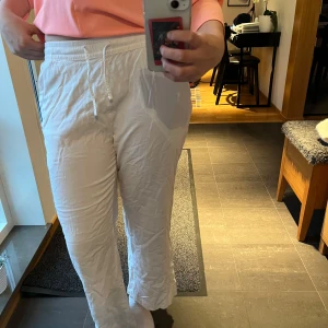 Vita linnebyxor med dragsko - Säljer ett par vita linnebyxor med resår och dragsko i midjan. Byxorna har raka ben och sidfickor, perfekta för en avslappnad stil. De är tunna och mjuka, perfekta för sommaren!💕Säljer de dem är för korta för mig som är 172 cm💕Lappen är avklippt där bak annars som vanligt💕Ny pris är 180kr