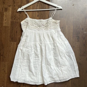 Vit sommarklänning med spetsdetaljer från Zara - Söt vit klänning från Zara med smala axelband och vackert virkad överdel med spetsmönster. Kjolen är luftig och har en lätt rynkad effekt. Perfekt för varma dagar och midsommarfirande. Använd några gånger!🥰💗