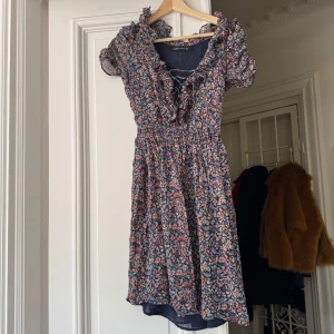 Blommig kortklänning från Zara Woman - Supersöt blommig klänning från Zara  med volangdetaljer och v-ringning. Perfekta klänningen inför sommaren. 