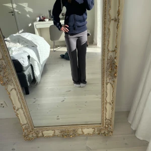 Gråa yogabyxor från NA-KD - Säljer ett par grå byxor från NA-KD i stretchigt material. Byxorna har en rak passform med låg midja och långa ben. Perfekta för en avslappnad och stilren look. Väl använda men inga tecken på användning. 