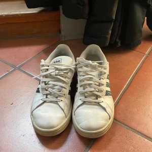 Vita adidas skor med blå detaljer - Säljer dessa snygga skor i storlek 38 och 2 tredjedelar. De har blå detaljer och är använda men inga hål eller liknande. Kontakta mig gärna privat vid frågor eller liknande💕