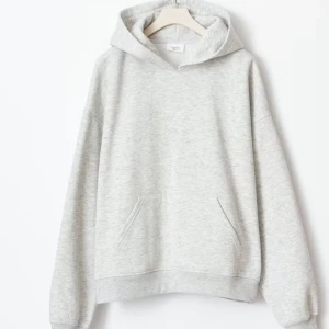 Ljusgrå hoodie med ficka - Säljer en stilren ljusgrå hoodie med huva och magficka. Perfekt för en avslappnad look och enkel att matcha med andra plagg. Mjuk och bekväm med lång ärm och klassisk passform.