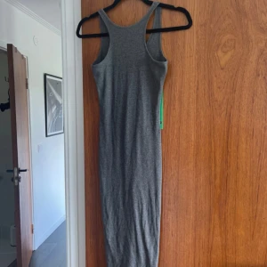 Ribbad klänning  - Grå ribbad klänning, vet ej storlek men strechig och passa nog XS-M. V-ringad rygg. 