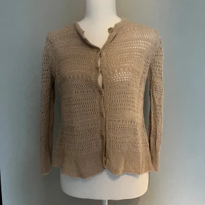 Beige stickad kofta med knappar - Säljer en beige stickad kofta med trekvarts ärm 