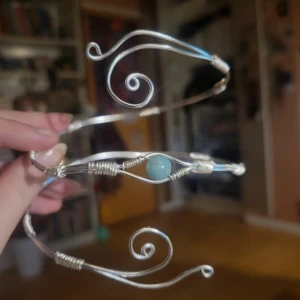 Handgjort Silvrigt armcuff med Grön aventurine sten och snirklig design - Unik armring i silverfärgad metall med handgjorda snirkliga detaljer och en blå rund sten i mitten. Armbandet är öppet och formas runt armen för en personlig passform. Perfekt för dig som gillar bohemisk och konstnärlig stil. Äkta Grön aventurine sten, silver rostar inte! 