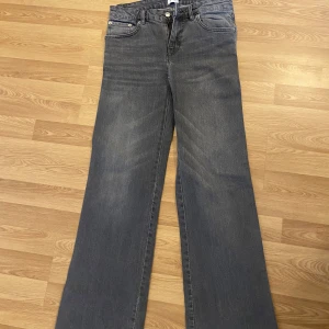 Gråa jeansbyxor med bootcut - Säljer ett par gråa jätte snygga  jeansbyxor med bootcut och klassisk femficksdesign. Byxorna har normal passform och dragkedja framtill. Perfekta för dig som gillar en avslappnad stil med lite vidare ben.
