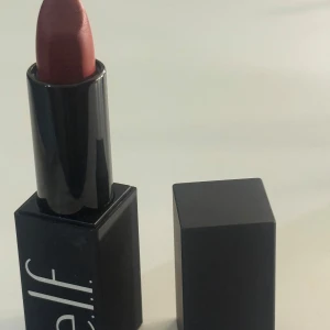 e.l.f. läppstift i färgen Do Not Disturb - Säljer ett e.l.f. läppstift i färgen Do Not Disturb. Läppstiftet har en matt finish och kommer i en stilren svart fyrkantig hylsa. Perfekt för dig som vill ha en djup röd nyans på läpparna.