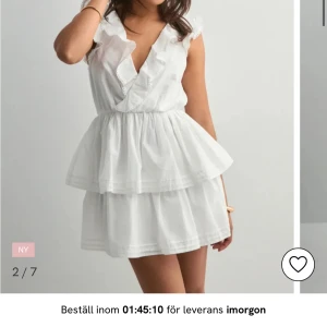 Vit volangklänning med v-ringning - Söt vit kortklänning med volangdetaljer och v-ringning. Klänningen har ärmlös design, omlott framtill och öppen rygg med knytband. Perfekt för sommarens alla tillfällen och studenten! Klänningen är endast provad, säljs eftersom jag inte längre kunde skicka tillbaka den till butiken. Skriv till mig för egna bilder💕