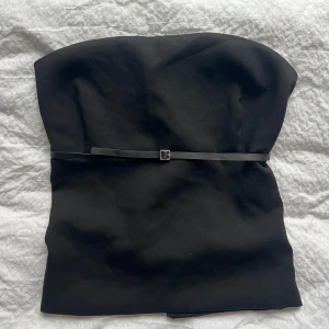 Festtopp - Svart bandå topp med spänne i fram och i ryggen. Toppen är i st XL men omsydd så att den passar mig som har s, då jag har gjort extra hål på banden i ryggen så den går att göra mindre! 