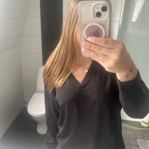 Svart glittrig blus från JDY - Säljer en svart blus från JDY med diskret glittrigt mönster och v-ringning. Säljer för jag ej använder. Jättebra skick.