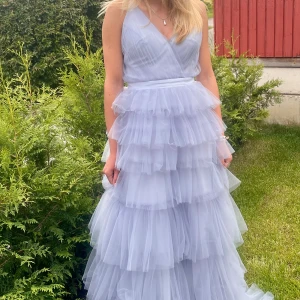 Ljusblå långklänning med volanger - Säljer nu min balklänning från förra året! Endast använd en gång och mycket bra skick. Storlek är 36/38.