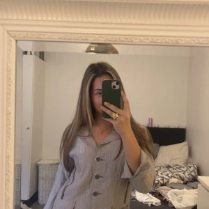 Beige kavaj med knappar och fickor - Säljer en beige kavaj med markerad krage och dekorativa sömmar i brunt. Mjukt och skönt material 