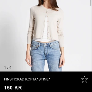 Beige finstickad kofta från Stine - Säljer en beige finstickad kofta från Stine. Koftan är croppad med rund halsringning och knappar framtill. Perfekt att styla över ett linne eller t-shirt. Enkel och stilren design som passar till mycket.