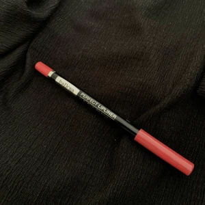 Perfect Lipliner från IsaDora i röd nyans - Säljer en IsaDora Perfect Lipliner i en snygg röd färg. Pennan har svart kropp med silvrig text och rött lock samt röd ände som matchar färgen. Perfekt för att definiera läpparna och få ett hållbart resultat.