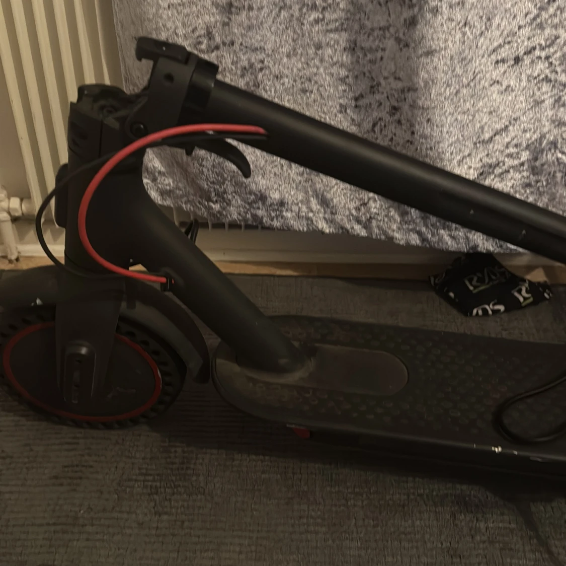 Svart elscooter med röda detaljer