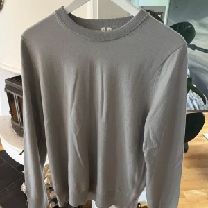 Grå långärmad tröja - Säljer en enkel och stilren grå långärmad tröja från Arket. Tröjan har rund halsringning och är tillverkad i ett mjukt material som passar perfekt till vardags. Passformen är normal och tröjan är lätt att matcha med olika outfits.