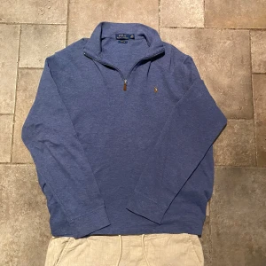 Ralph Lauren Quarter Zip Large - Ljusblå Ralph Lauren Quarter Zip i extremt gott skick utan tecken på användning. 100% äkta och fungerar otroligt bra inför sommaren med den ljusa färgen.