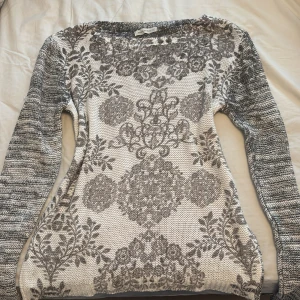 Y2K  stickad tröja med mönster - Säljer en y2k stickad tröja i grått och vitt med snyggt blommigt.