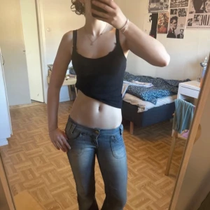 Blå bootcut jeans från Lee - Säljer ett par blå bootcut jeans från Lee med klassisk femficksdesign och snygga slitningar framtill. Jeansen har låg midja och guldiga knappar på bakfickorna. Perfekta för dig som gillar en retro vibe☺️. säljer dom på grund av att dom är för små för mig annars finns det inga defekter alls UTOM slitningarna längst ner, dock så tänker man ej på det!! Jag är 163 cm lång och de passar mig perfek